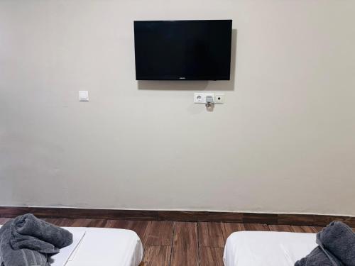 コス・タウンにあるAlekas Garden View Studiosの壁に薄型テレビが取り付けられた部屋