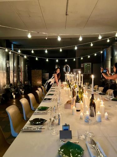 a long table with candles and bottles of wine at MiaClara Relais in Alba