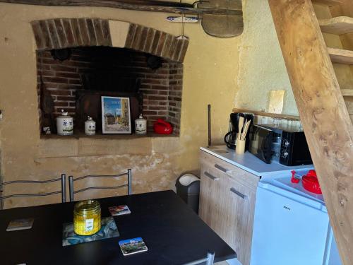 L ancien fournil - Sejour authentique & douillet - Proche de Sarlat في Calviac: مطبخ مع ثلاجة وطاولة عمل