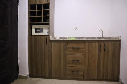 a kitchen with a sink and a microwave at Serviced Apartment Direct in Abuja