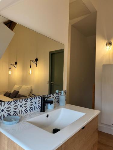 une salle de bain avec un lavabo et un grand miroir dans l'établissement Nouveauté! Tout juste rénové, à Saint-Benoît-sur-Loire