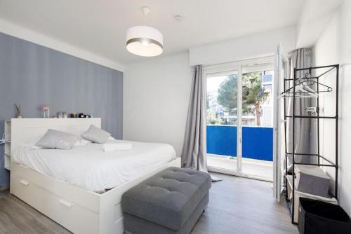 - une chambre avec un lit blanc, une chaise et une fenêtre dans l'établissement COSY MOON 3P, wifi, climatisé, 6 pers, classé 3 étoiles, à Cannes