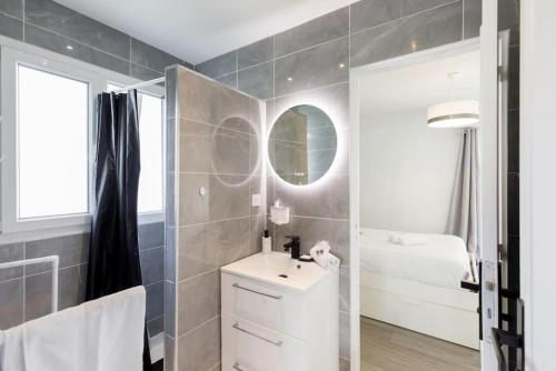 une salle de bain avec un lavabo et un miroir dans l'établissement COSY MOON 3P, wifi, climatisé, 6 pers, classé 3 étoiles, à Cannes