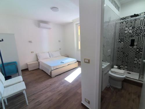 a white room with a bed and a shower at Camera Appartamento Terminal Traghetti in Genova