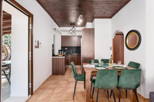 a dining room with a table and green chairs at Villa Foteini Gerakari Mountain Resort in Yerakárion