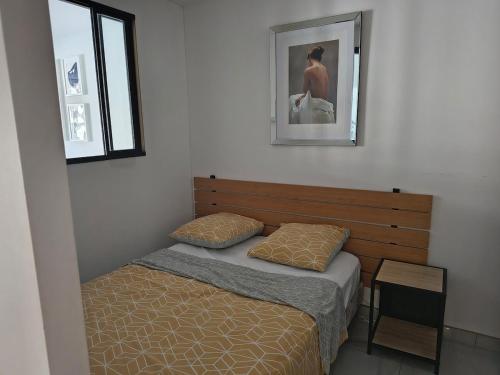 une chambre avec un lit et un tableau au mur dans l'établissement Appartement bord de mer, à La Grande Motte