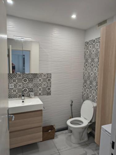 une salle de bain avec toilettes et lavabo dans l'établissement Appartement bord de mer, à La Grande Motte