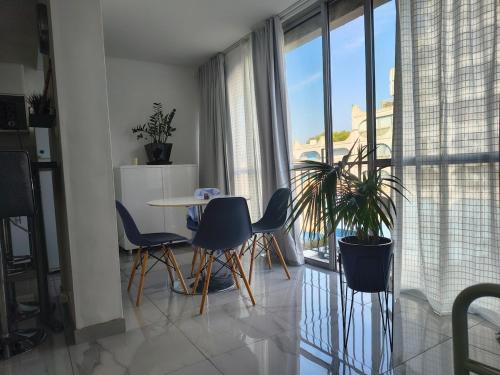 un salon avec une table et des chaises et une fenêtre dans l'établissement Appartement bord de mer, à La Grande Motte