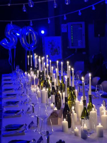 a table with white candles and bottles of wine at MiaClara Relais in Alba