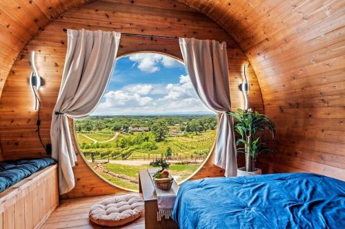 a bedroom with a large window in a wooden room at Vineyard Cottage in Wine Country with Hot Tub in Jonesville