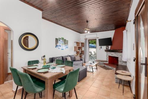 a living room with a table and green chairs at Villa Foteini Gerakari Mountain Resort in Yerakárion