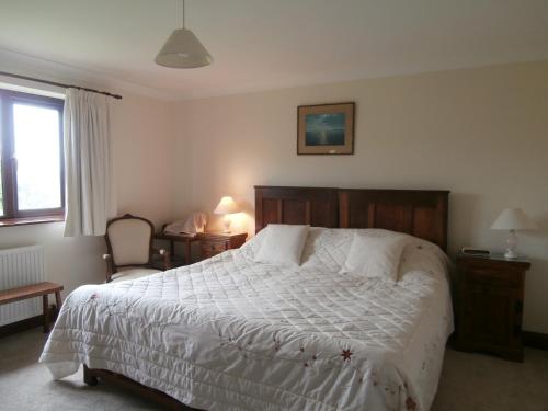 a bedroom with a bed and a chair and a window at Highfield in Hay-on-Wye