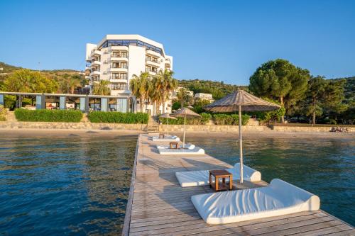 a row of lounge chairs and umbrellas on a beach at Med-Inn Hotel in Gulluk