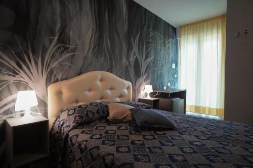 A bed or beds in a room at Hotel Alemagna Bed&Breakfast Bibione Lido del Sole