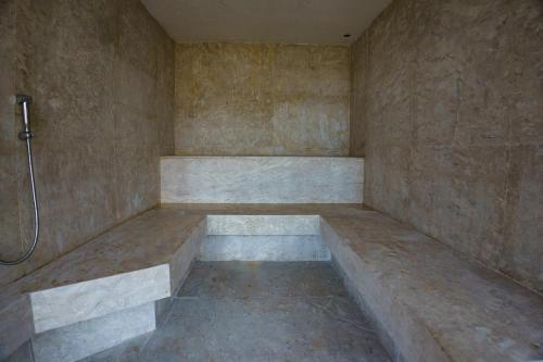 a bathroom with a shower with a bench in it at Duke Beach Hotel Maresias in Maresias