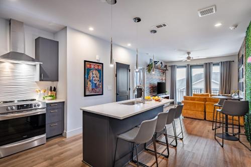 a kitchen and living room with a sink and a counter at The Odyssey Apartments by AvantStay in Nashville