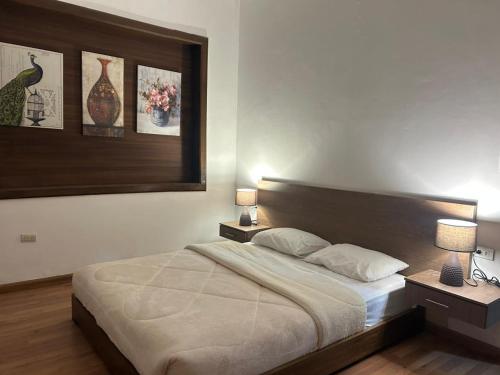 a bedroom with a bed with two lamps and two tables at Hotel San Benito Cuenca in Cuenca