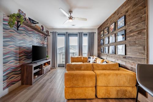a living room with a couch and a tv at The Odyssey Apartments by AvantStay in Nashville