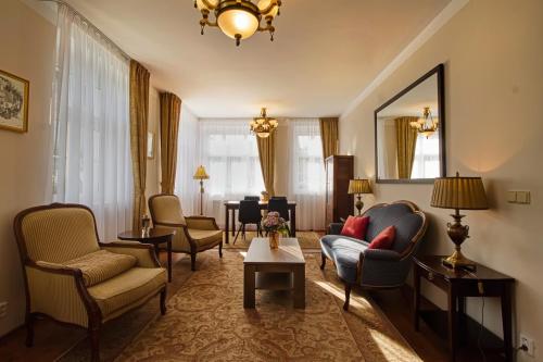 a living room with couches and chairs and a mirror at Villa Patriot Apartmány in Mariánské Lázně