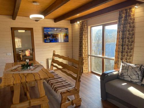 a living room with a wooden table and a couch at На Замковiй горi in Kosiv