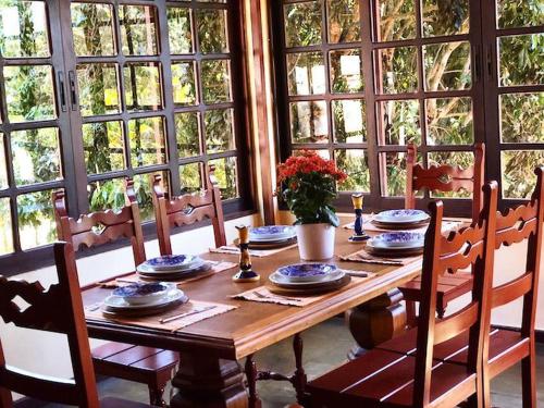 a wooden table with chairs and a vase of flowers at VILLA MIA DUO in Itaipava