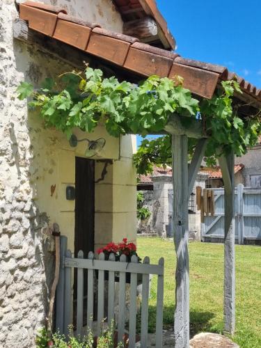 une clôture blanche devant une maison avec une porte dans l'établissement Le soleil couchant en Périgord, à La Gonterie-Boulouneix