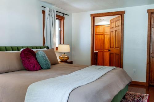 a bedroom with a large bed and a wooden door at Creek-Hot Tub-View-Pets-10min DT in Durango