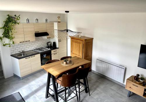- une cuisine avec une table et des chaises en bois dans la chambre dans l'établissement La Grange Saint-Laurent, 