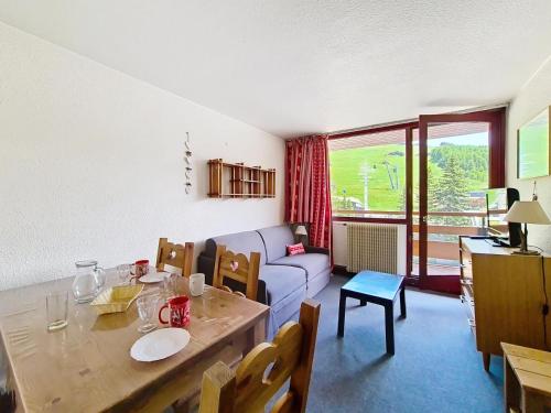 un salon avec une table et un canapé dans l'établissement Résidence Vanoise - Appartement lumineux · Centre station · Balcon MAE-2214, aux Menuires