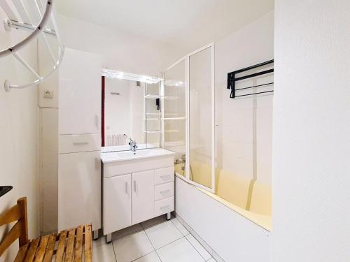 une salle de bain blanche avec un lavabo et une douche dans l'établissement Résidence Vanoise - Appartement lumineux · Centre station · Balcon MAE-2214, aux Menuires