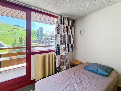 une chambre avec un lit et une fenêtre avec vue dans l'établissement Résidence Vanoise - Appartement lumineux · Centre station · Balcon MAE-2214, aux Menuires
