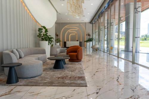 a lobby with a couch and chairs and tables at Deluxe Condo Suite 1BR with Ocean View in Panama City