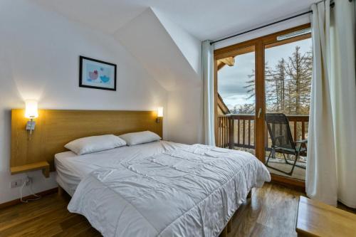 une chambre avec un lit et un balcon dans l'établissement Les Chalets De Bois MÉan - D - Bel appartement 8 couchages rénové aux Orres 1800 MAE-5894, aux Orres