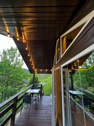 a deck with tables and chairs on a house at Файна хата 4 in Synevyrsʼka Polyana