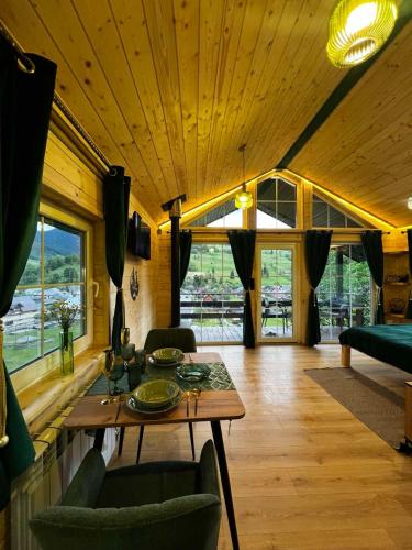 a living room with a wooden ceiling and a table at Файна хата 4 in Synevyrsʼka Polyana