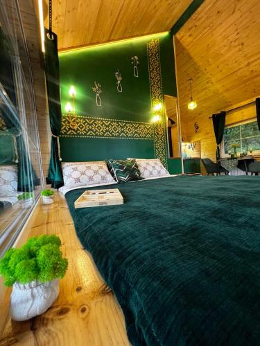 a bedroom with a large bed with a green headboard at Файна хата 4 in Synevyrsʼka Polyana