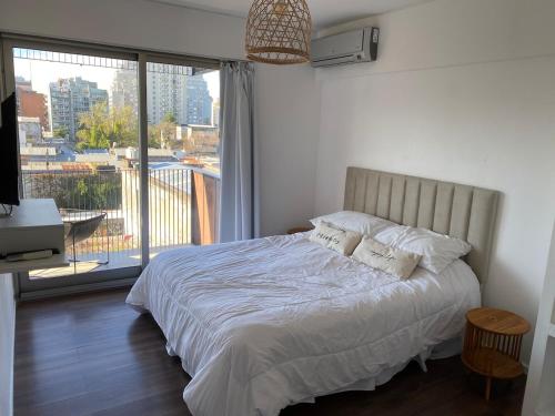 a bedroom with a bed and a large window at Apartment in central Palermo, BsAs, full amenities in Buenos Aires