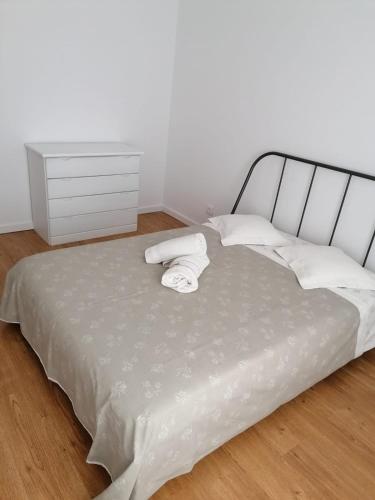 a bed with two towels and a dresser in a room at Casa acolhedora in Ponte da Barca