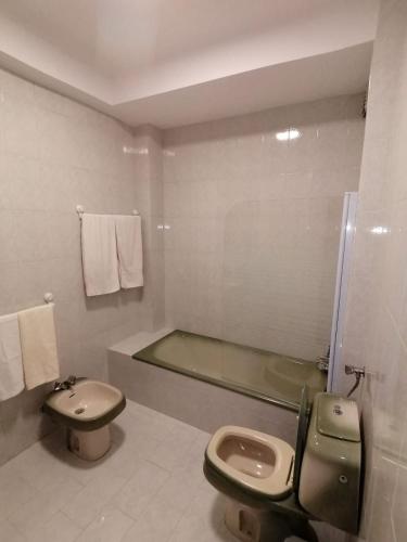 a bathroom with a toilet and a sink and a tub at Casa acolhedora in Ponte da Barca