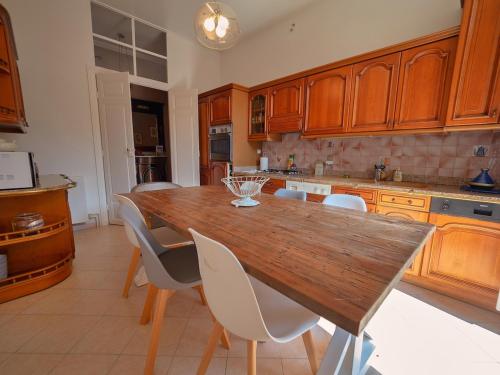 - une cuisine avec une table en bois et des chaises blanches dans l'établissement côté palais, à Bastia
