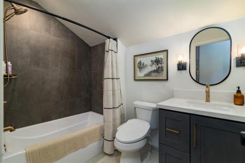 a bathroom with a tub and a toilet and a sink at Cozy Zion Retreat Hot Tub 2 King Bedrooms in Orderville