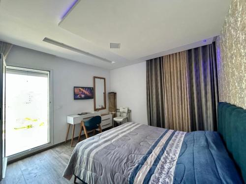 a bedroom with a bed and a desk and a window at RÉSIDENCE LA TERRASSE s2 AVEC BALCON & TERRASSE "Only Family" in Hammamet