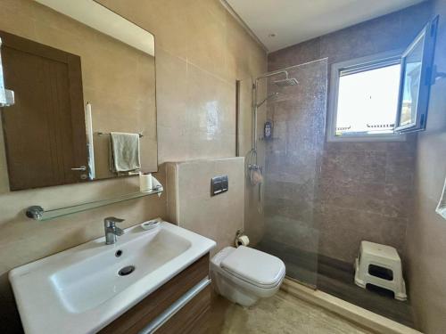 a bathroom with a sink and a toilet and a window at RÉSIDENCE LA TERRASSE s2 AVEC BALCON & TERRASSE "Only Family" in Hammamet