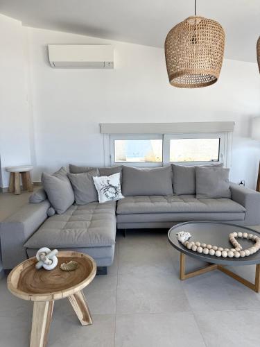 a living room with a couch and a table at PETRA Luxury Villas in Áyioi Apóstoloi