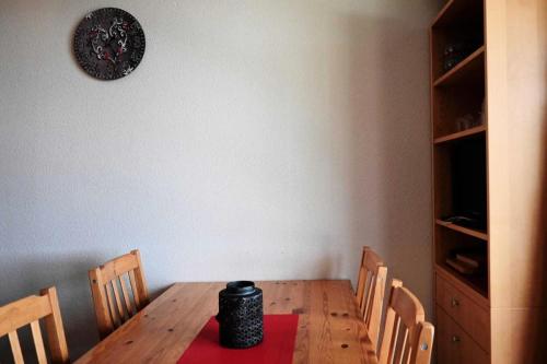 une table à manger avec des chaises et une horloge murale dans l'établissement Résidence Cret De L'ours 1 - Appartement 2 pièces 4 personnes à Vallandry proche des pistes et des commerces MAE-5111, à Peisey-Nancroix