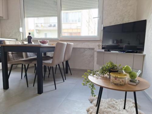 a kitchen and dining room with a table and chairs at Apartment Riverside in Metković
