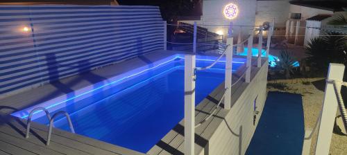 a swimming pool at night with blue illumination at Pool Seaside Relais - VILLE Ninfea, Marea, Rosa e Cassiopea in Fontane Bianche