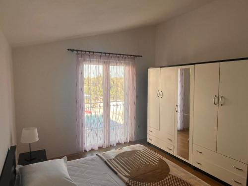 a bedroom with a bed and a large window at Apartment Milat in Seget Donji