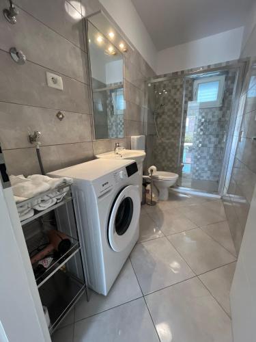 a bathroom with a washing machine and a sink at Apartments Cezar in Stobreč