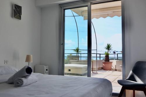une chambre avec un lit et une vue sur un balcon dans l'établissement LES ANGES -F2 Appartement, terrasse vue mer, piscine, wifi, à Villeneuve-Loubet